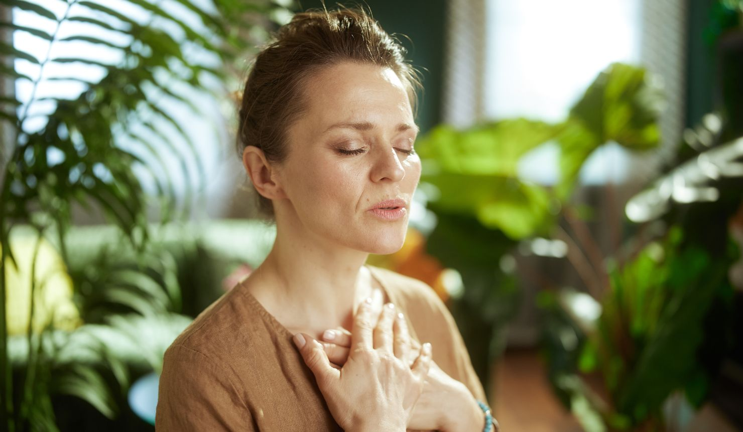 Woman practicing mindful breathing to calm the nervous system and reduce stress.