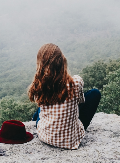 Woman pausing at a cliff edge to step away from emotional spirals