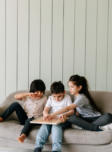 Children gathered on a couch with their unique personalities shining, showing the everyday miracles of family and connection