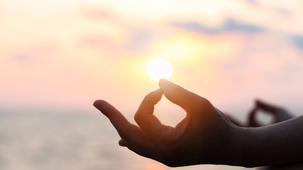 guided meditation for letting go with hand resting on knee in sunlight