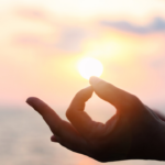 guided meditation for letting go with hand resting on knee in sunlight