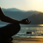 meditation tips for allowing and letting go with hand resting on knee at beach