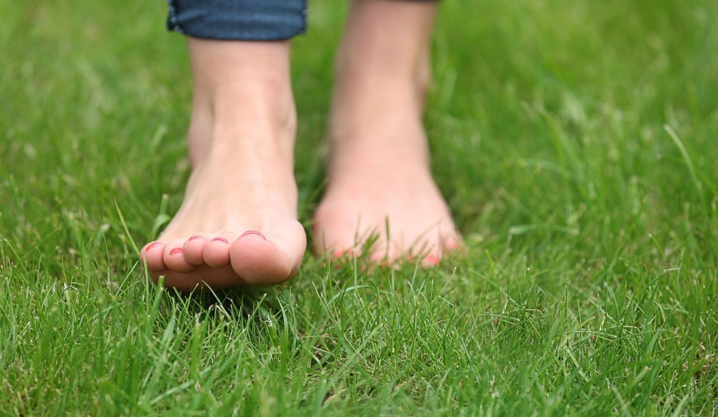 Bare feet gently walking through grass as a grounding practice for nervous system regulation, self compassion, and emotional clarity.