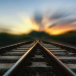 Railroad tracks stretching toward a glowing sunrise, symbolizing change, new beginnings, and the journey of personal growth.