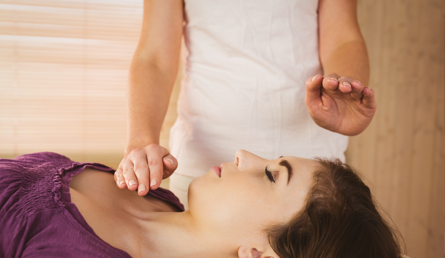Woman performing Reiki energy healing on another woman during a calming session